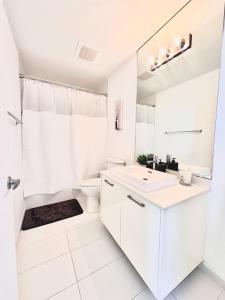 Luxe Loft Heart of Miami Brickell Downtown في ميامي: حمام أبيض مع حوض ومرحاض