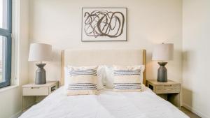a bedroom with a white bed with two night stands at Landing at Logan Apartments - 1 Bedroom in Logan Square in Chicago