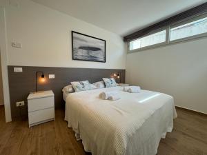 a bedroom with two beds and a table and a window at Villa Sunshine in Lignano Sabbiadoro