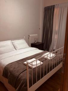 a bedroom with a white bed with a crib at Spartan Townhouse Apt 3 Leonidas in Sparti