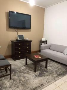 a living room with a couch and a flat screen tv at Spartan Townhouse Apt 3 Leonidas in Sparti