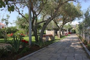a walkway in a park with trees and flowers at Holiday House Zaton in Nin