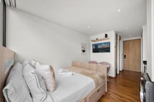una camera da letto con un grande letto con lenzuola bianche di FH - Iluminating studio in Chico - Bogota a Bogotá