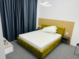 um quarto com uma cama com uma armação de cama amarela em GRAND Caciulata em Caciulata