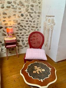 une chambre avec une chaise rouge et une table avec une lampe dans l'établissement Vercors en Vert , chambres d'hôtes de charme, à Saint-Romans