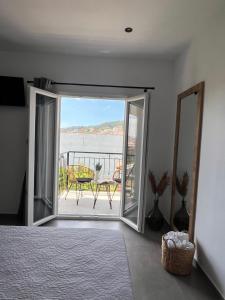 een slaapkamer met een deur naar een balkon bij Cactus in Skiathos-stad