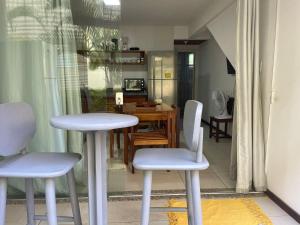 a kitchen with a table and two white chairs at TRANQUILA CONDO in Morro de São Paulo