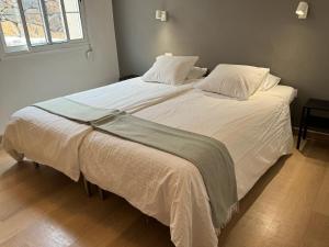 a bedroom with a large bed with white sheets and a window at Tendal Hosting - El Mirador de Cristina in Breña Alta