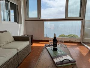 a living room with a couch and two glasses of wine at Tendal Hosting - El Mirador de Cristina in Breña Alta