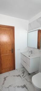 La salle de bains blanche est pourvue d'un lavabo et d'un miroir. dans l'établissement Casa en La Paz, à Puerto de la Cruz