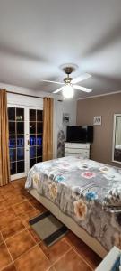 - une chambre avec un lit et un ventilateur de plafond dans l'établissement Casa en La Paz, à Puerto de la Cruz