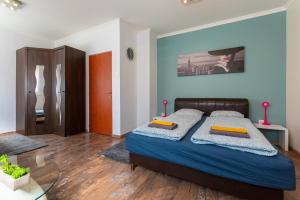 a bedroom with a bed with blue walls and wooden floors at R APARTMENTS BUDAPEST in Budapest