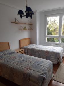 1 dormitorio con 2 camas y ventana en Apartamento zona de los osos, en Santander