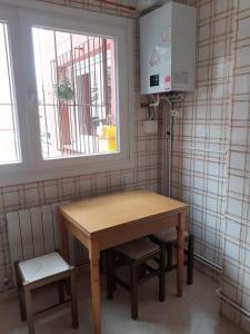 una mesa y una silla en una habitación con ventana en Apartamento zona de los osos, en Santander