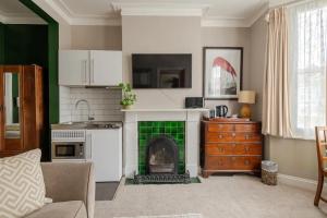 a living room with a fireplace and a kitchen at Deco Studio: King bed, kitchenette, stylish & comfortable in Brighton & Hove