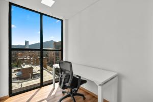 oficina con escritorio, silla y ventanas grandes en FH - Fashionable studio in Chico - Bogota, en Bogotá