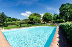 - une piscine dans une cour avec des chaises et des arbres dans l'établissement Ferienhaus mit Privatpool für 6 Personen ca 120 qm in Montecarlo, Toskana Provinz Pistoia, à Montecarlo