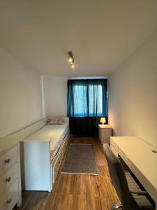 a bedroom with a bed and a desk and a window at Mieszkanko na Sopockiej polanie. in Sopot