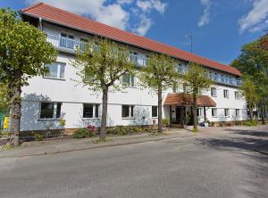 een wit gebouw met een rood dak op een straat bij Meduza Sopot in Sopot