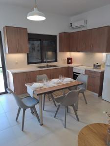 a kitchen with a wooden table and chairs in it at Olea Homes in Plátanos