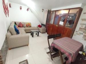 un soggiorno con un divano e un tavolo di HOSTAL La RASA a Cuzco