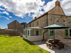 un ombrello e un tavolo da picnic di fronte a un edificio di 5 Bedroom Cottage - Somerset Pass the Keys a Shapwick