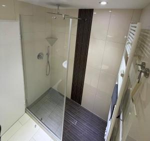 a shower with a glass door in a bathroom at Traumhafte Ferienwohnung - direkter Meerblick - 50m zum Strand in Cuxhaven Duhnen in 1A Lage im Haus Seehütte in Cuxhaven
