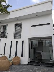 a white house with two chairs in front of it at Ujuuu apartments in Lekki