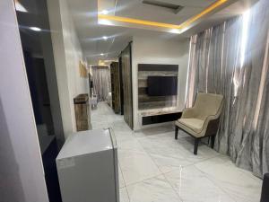 a living room with a television and a chair at Ujuuu apartments in Lekki