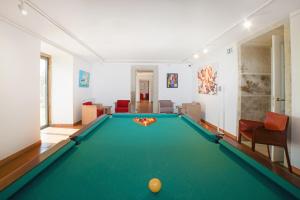 a pool table in a living room with a pool ball at Solar das Bouças in Amares