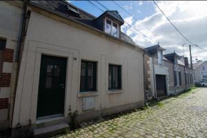 a white building with a door on a street at Maisonbroca in Bourges