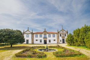 an estate with a fountain in front of a building at Solar das Bouças by Quantique in Amares