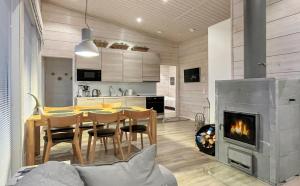 a kitchen and dining room with a table and a fireplace at Villa Paadar in Inari