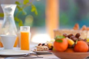 un tavolo con un cesto di frutta e un bicchiere di succo d'arancia di Villa Taouzert a Tozeur