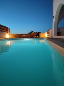 uma piscina à noite com as luzes acesas em Daphne's place em Vívlos