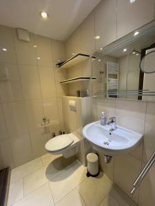 a white bathroom with a sink and a toilet at Traumhafte Ferienwohnung - direkter Meerblick - 50m zum Strand in Cuxhaven Duhnen in 1A Lage im Haus Seehütte in Cuxhaven
