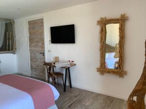 a bedroom with a bed and a mirror and a table at VILLA MACAGNA in Corbara