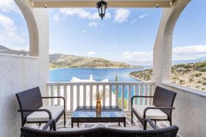 a balcony with a table and chairs and a view of the ocean at Villa Corali in Pefkali