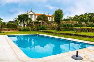 a swimming pool in front of a house at Solar das Bouças in Amares