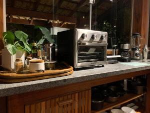 La cocina está equipada con tostadora, horno y encimera. en Glamping Casa D'Arvore Camburizinho, en São Sebastião 29 fotos más