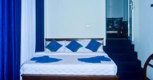 a bedroom with a bed with blue pillows at YaYa Lodge Haputale in Haputale