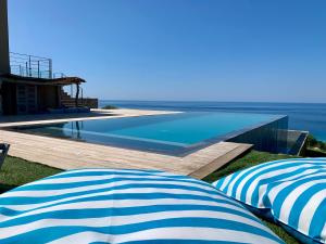 two blue and white umbrellas sitting next to a swimming pool at VILLA MACAGNA in Corbara