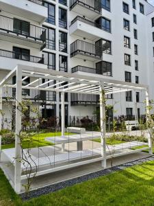 a white apartment building with a pavilion in front of it at M&M Doki Studio in Gdańsk