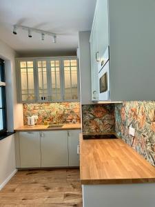 a kitchen with white cabinets and a counter top at M&M Doki Studio in Gdańsk +18 photos