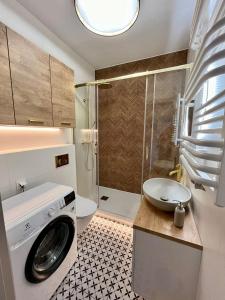 a washing machine in a bathroom with a shower at M&M Doki Studio in Gdańsk