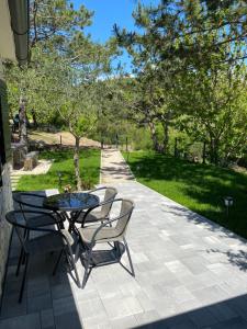 un patio con tavolo, sedie e alberi di Normabella Holiday Home a Tugare