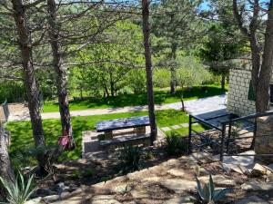 un tavolo da picnic e una panchina in un parco alberato di Normabella Holiday Home a Tugare