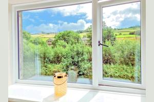 a window with a view of a field at THE OLD WASH KITCHEN - Charming Character Cottage in Holmfirth, Yorkshire in Holmfirth