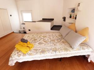 um quarto com uma cama com um cobertor amarelo em Terrazzaconvista - sui tetti della città vecchia em Gênova