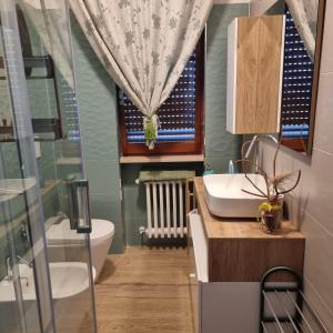 un bagno con lavandino, water e finestra di DOC'S HOUSE a Silvi Marina